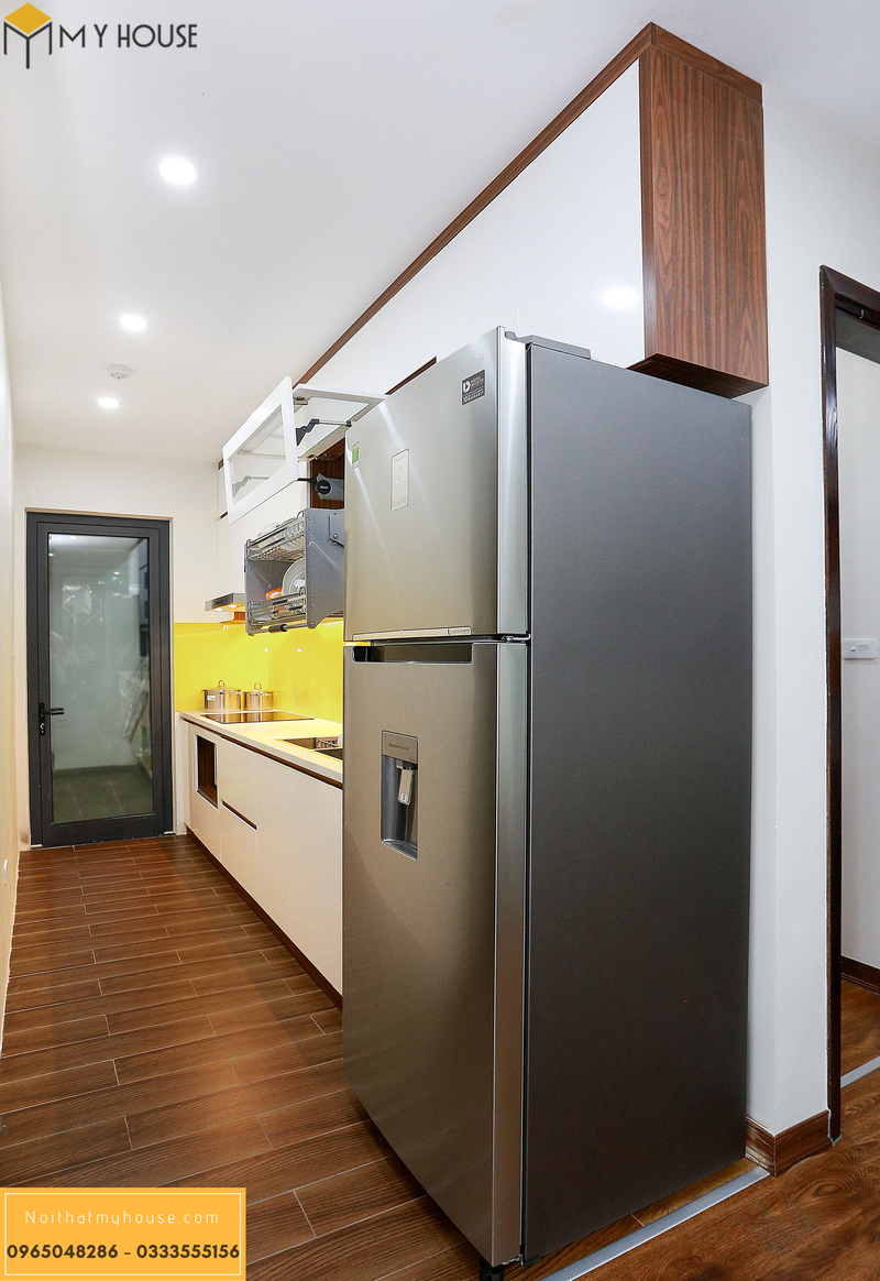 Tủ bếp với tông màu trắng, kết hợp kính ốp tường vàng nổi bật